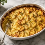 Vegan potato bake slice with golden layers, creamy oat milk sauce,