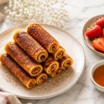Quick Cinnamon Sugar French Toast Roll-Ups served with strawberries and maple syrup on white marble