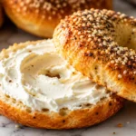 High protein cottage cheese bagel with cream cheese and everything bagel seasoning on a marble countertop