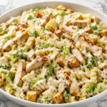 Creamy Chicken Caesar Pasta Salad with rotini, grilled chicken, romaine lettuce, parmesan, and crunchy croutons.