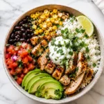 Healthy chicken burrito bowl with cilantro lime rice, black beans, grilled corn, avocado, pico de gallo and chicken.