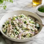 Creamy tzatziki chicken salad with shredded chicken, cucumber, feta, dill, and red onion served in a rustic ceramic bowl.